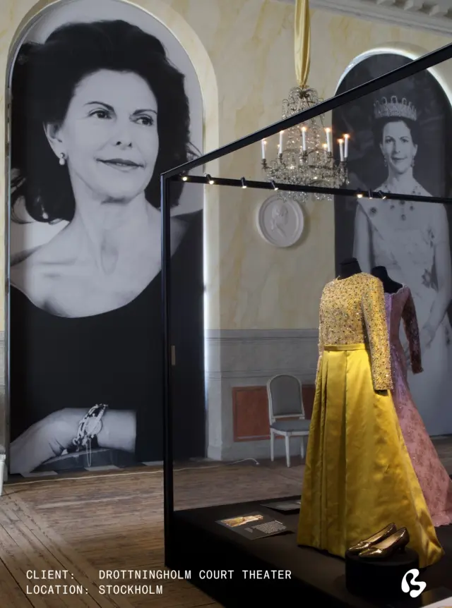 The story of a reign, brought into the room.

Every exhibition presents its own scenographic challenge. For The Queen's Royal Wardrobe at Drottningholm Court Theatre, it was to allow the garments to be experienced without compromising the visitor experience.

In our Stockholm studio, Big Image transformed the palace windows with monumental premium printed portraits of Her Majesty Queen Silvia. Alongside the portraits, we developed and built custom aluminium constructions, covered with an almost invisible mesh that quietly blends into the space.

The exhibition is currently on view at Drottningholm Court Theatre until July 26.

Curator: Anna Kjellsdotter
@drottningholmsslottsteater 
.
.
.
.
.
.
.
exhibition, exhibition design, art exhibit, art exhibition, art design

#147542