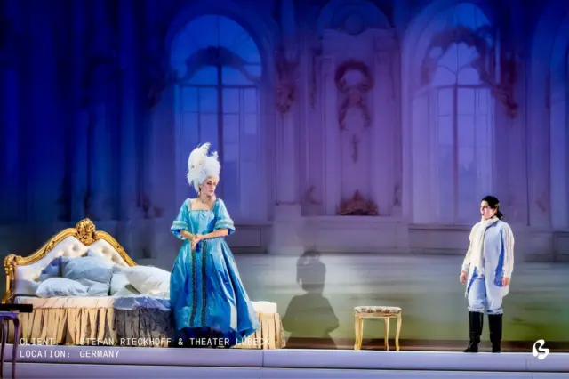 A softness that holds an entire world.

For Der Rosenkavalier at Theater Lübeck, the long-standing collaboration between Big Image and Stefan Rieckhoff, continues in a scenography shaped by lightness – unfolding in the first act.

The backdrop, printed on gobelin tulle, carries soft, AI-enhanced imagery that allows light to move freely through the space. Layered with rear projection, the result is a delicate interplay of clarity and translucency.

Set Design: Stefan Rieckhoff
Costume Design: Tanja Liebermann
Lighting Design: Falk Hampel
Photo Credit: Jochen Quast
.
.
.
.
.
.
set design, set designer, scenography, scenic design, scenic designer, light design, light designer, production design, production designer, custom solution, big image

#143715